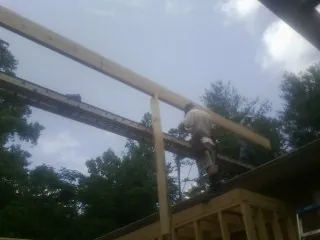 Carpenter setting a ridge beam over a new addition frame — Ice Dam Removal by Roofing Brothers in Boones Mill