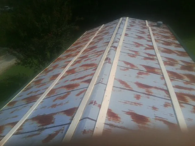 Rusted metal roof panels with new wood purlins before replacement — Storm Damage Roof Repair in Boones Mill by Roofing Brothers