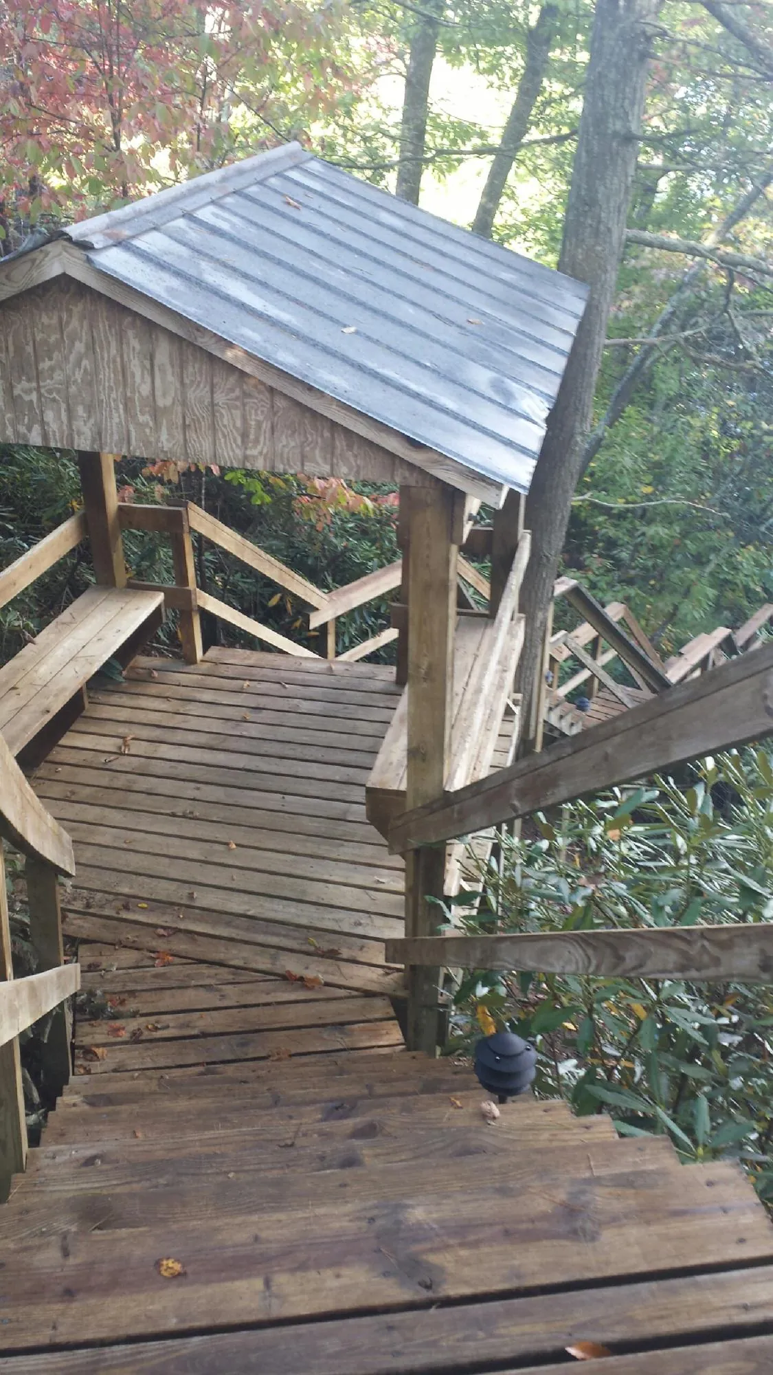 Metal roofed shelter over wooden steps on a wooded walkway — Skylight Repair & Installation work by our crew in Boones Mill