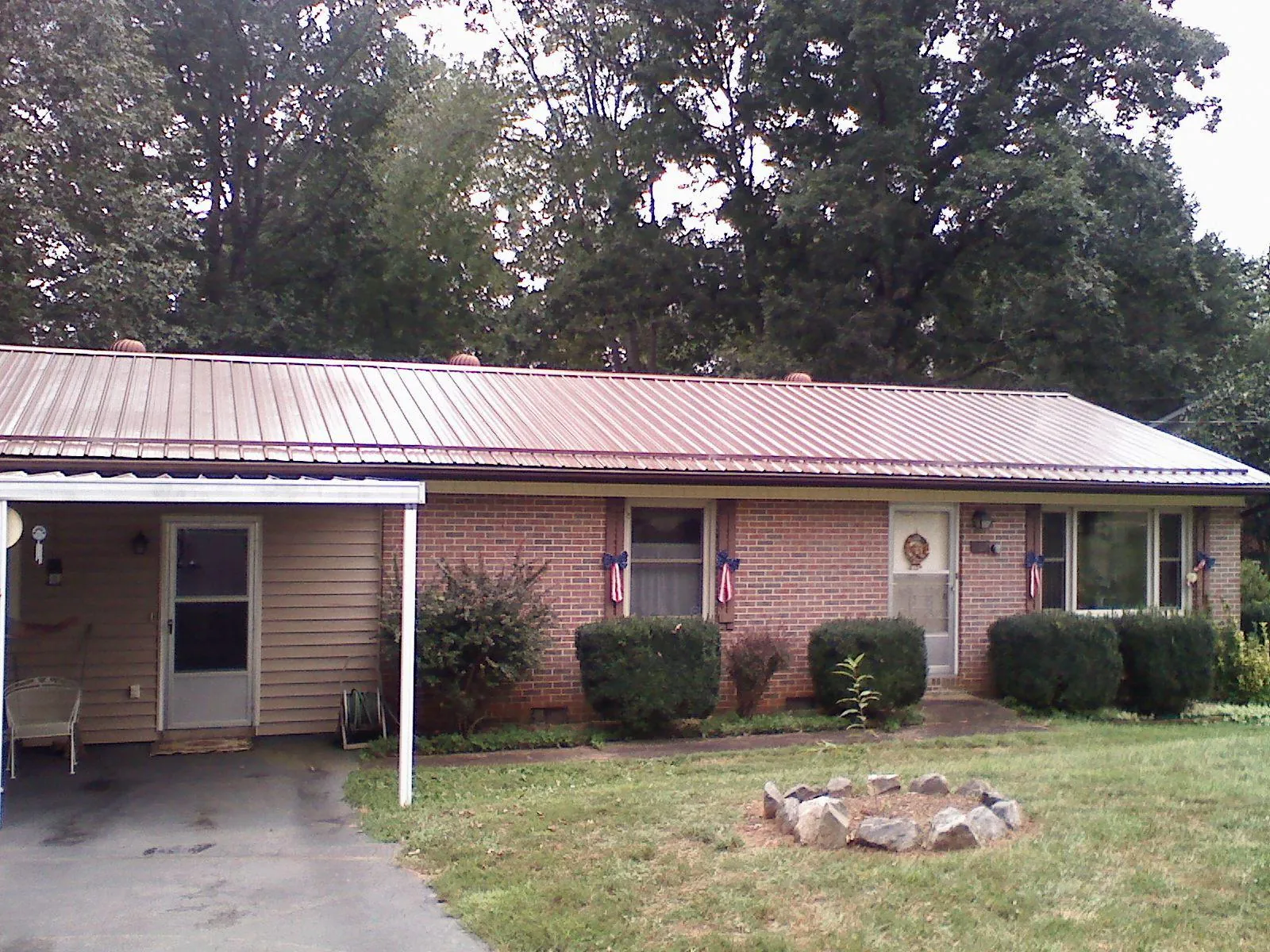 Bronze metal roof and carport on a brick ranch home — Roof Repair work by our crew in Boones Mill