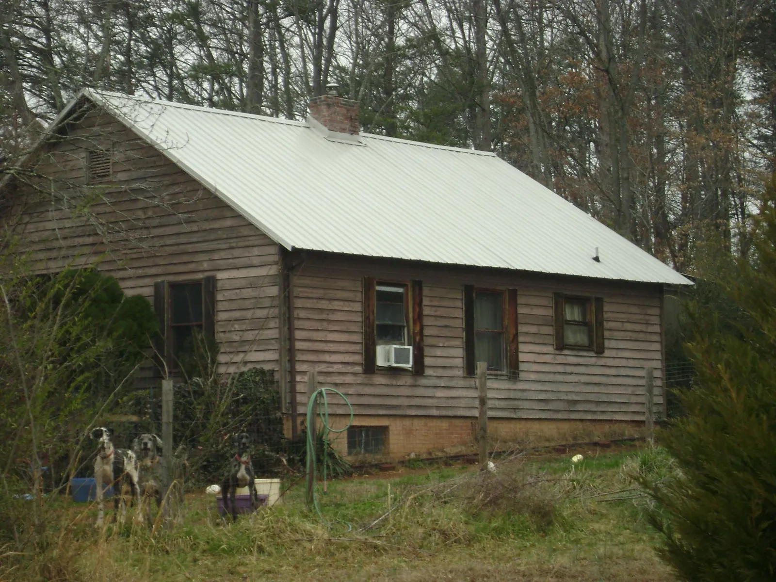 White metal roof on an old wood sided farmhouse, from a Asphalt Shingle Roof Repair job in Boones Mill